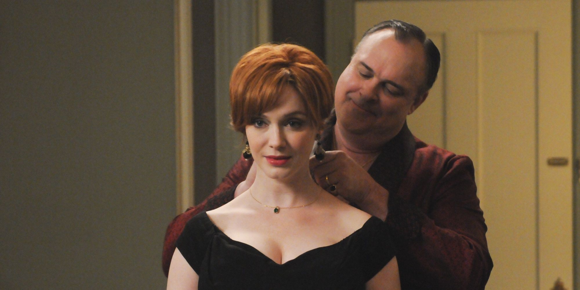 Herb putting a necklace on Joan in Mad Men