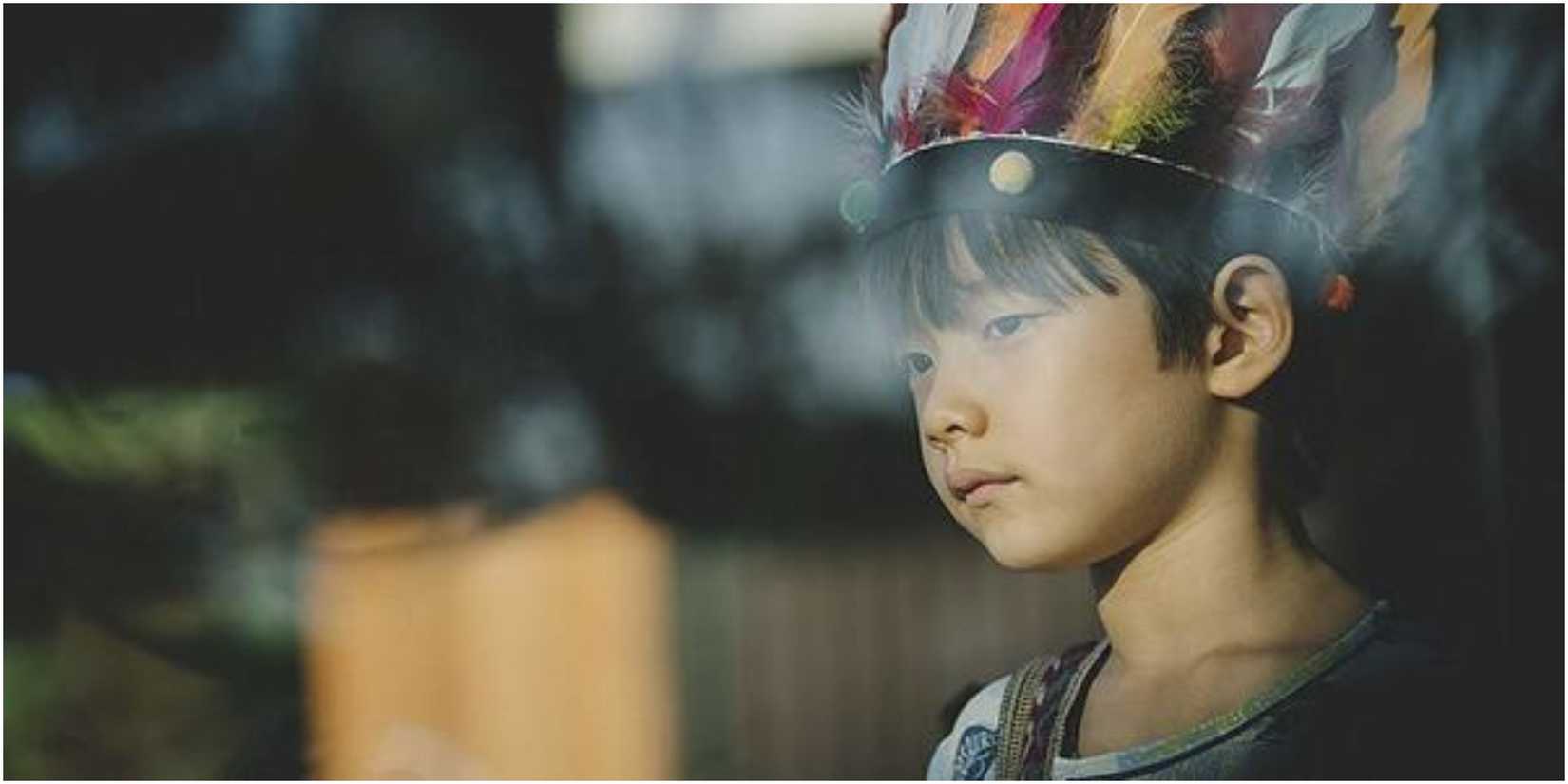 Park Da-song (Jung Hyeon-jun) wearing a Native American headdress in Parasite.