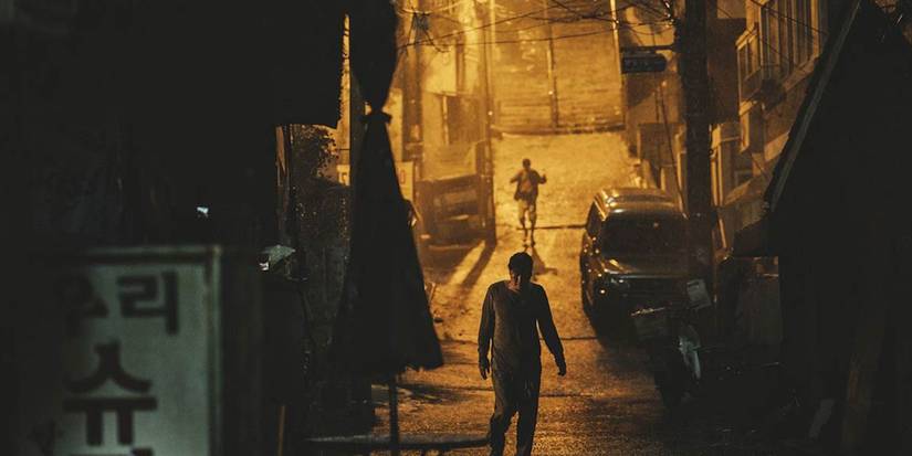 A massive rain storm in the streets with two people walking in Parasite.