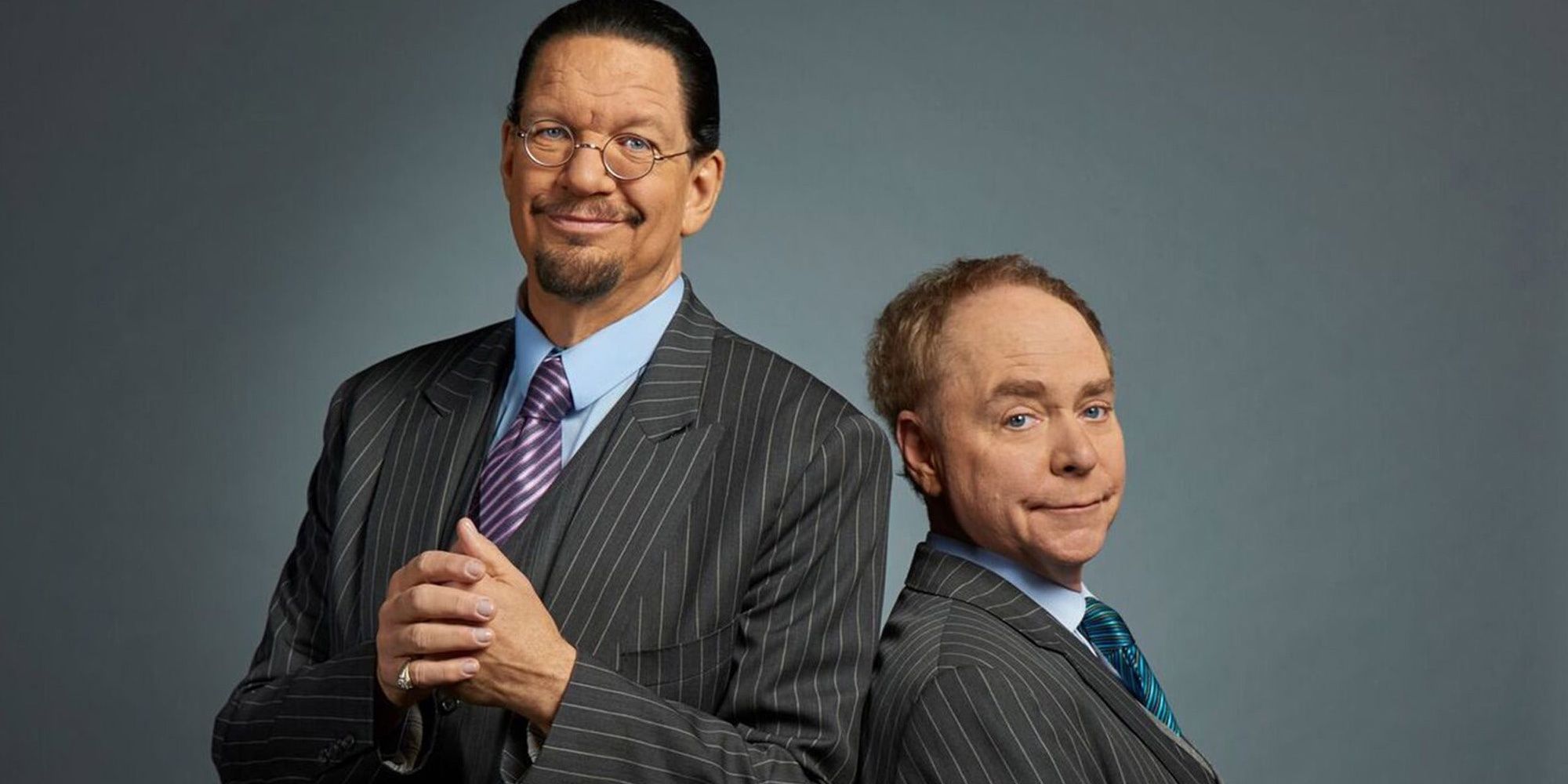 Penn and Teller stand back-to-back in front of a grey background.