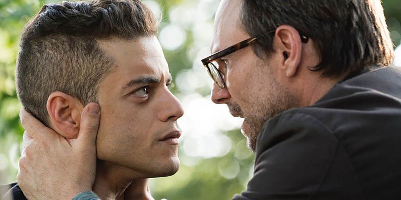 Rami Malek as Elliot Alderson and Christian Slater as Mr. Robot, Mr. Robot holds Elliot's face as they look at each other intensely