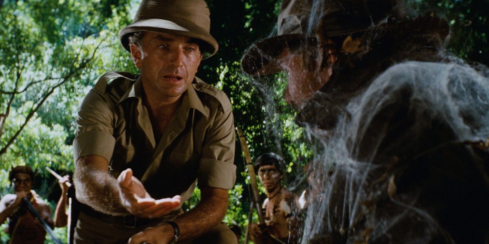 Rene Belloq intimidatingly holds out his hand in the jungle in Raiders of the Lost Ark