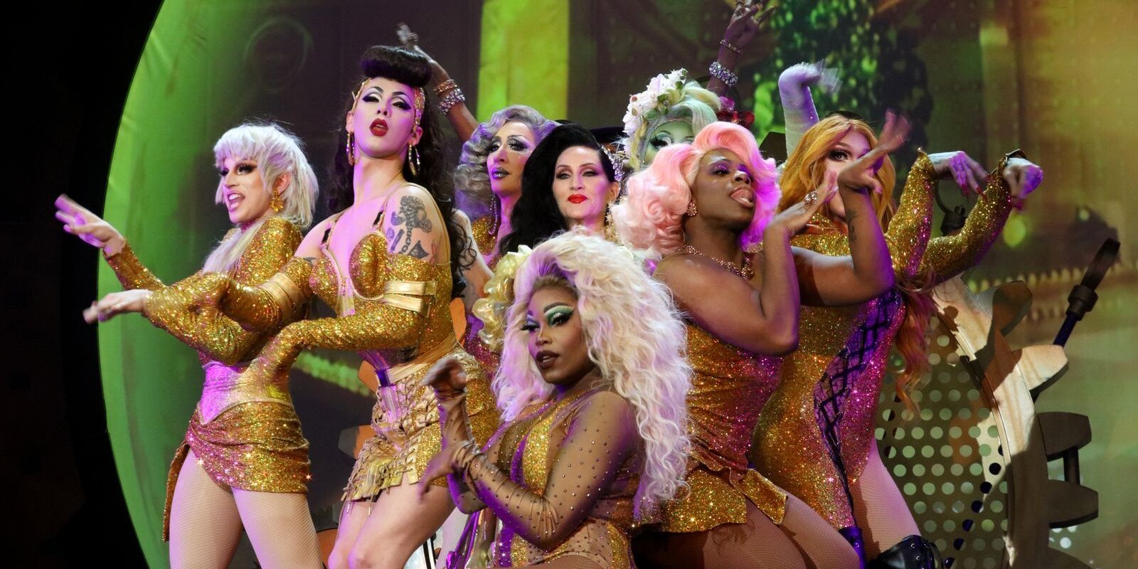 Michelle Visage on stage appears on stage surrounded by a gaggle of drag queens