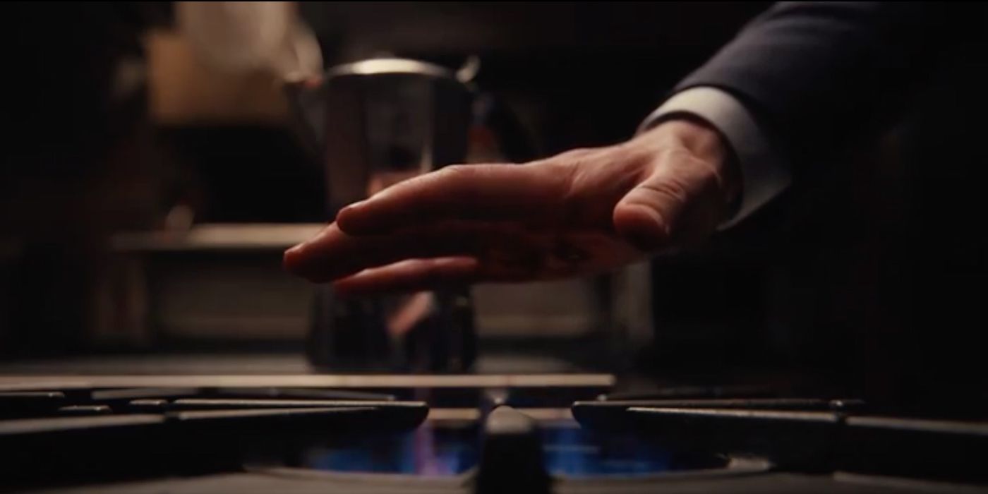 A close up of Sean's hand being held over a lit gas burner stove