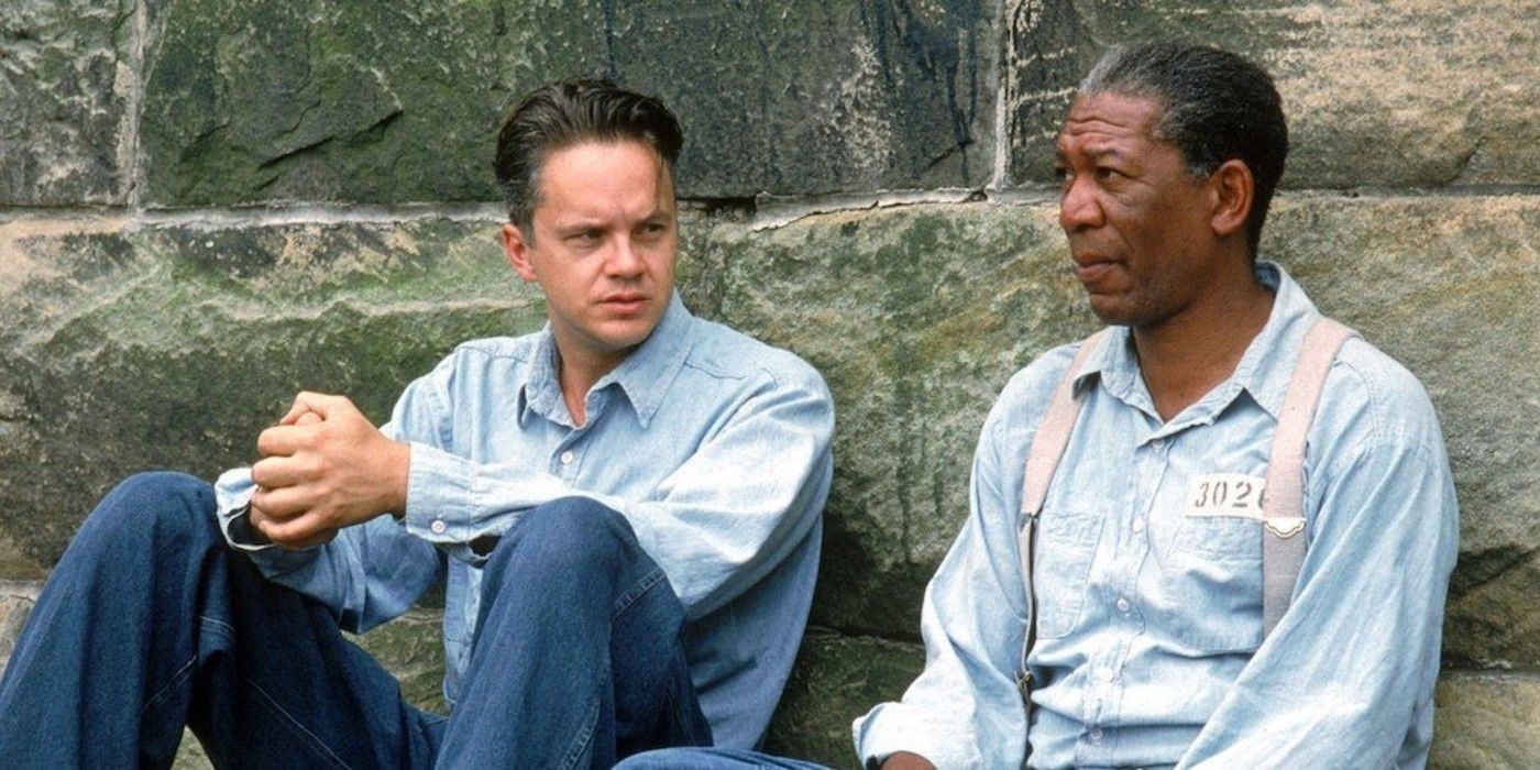 Andy (Tim Robbins) e Red (Morgan Freeman) encostados em uma parede em The Shawshank Redemption