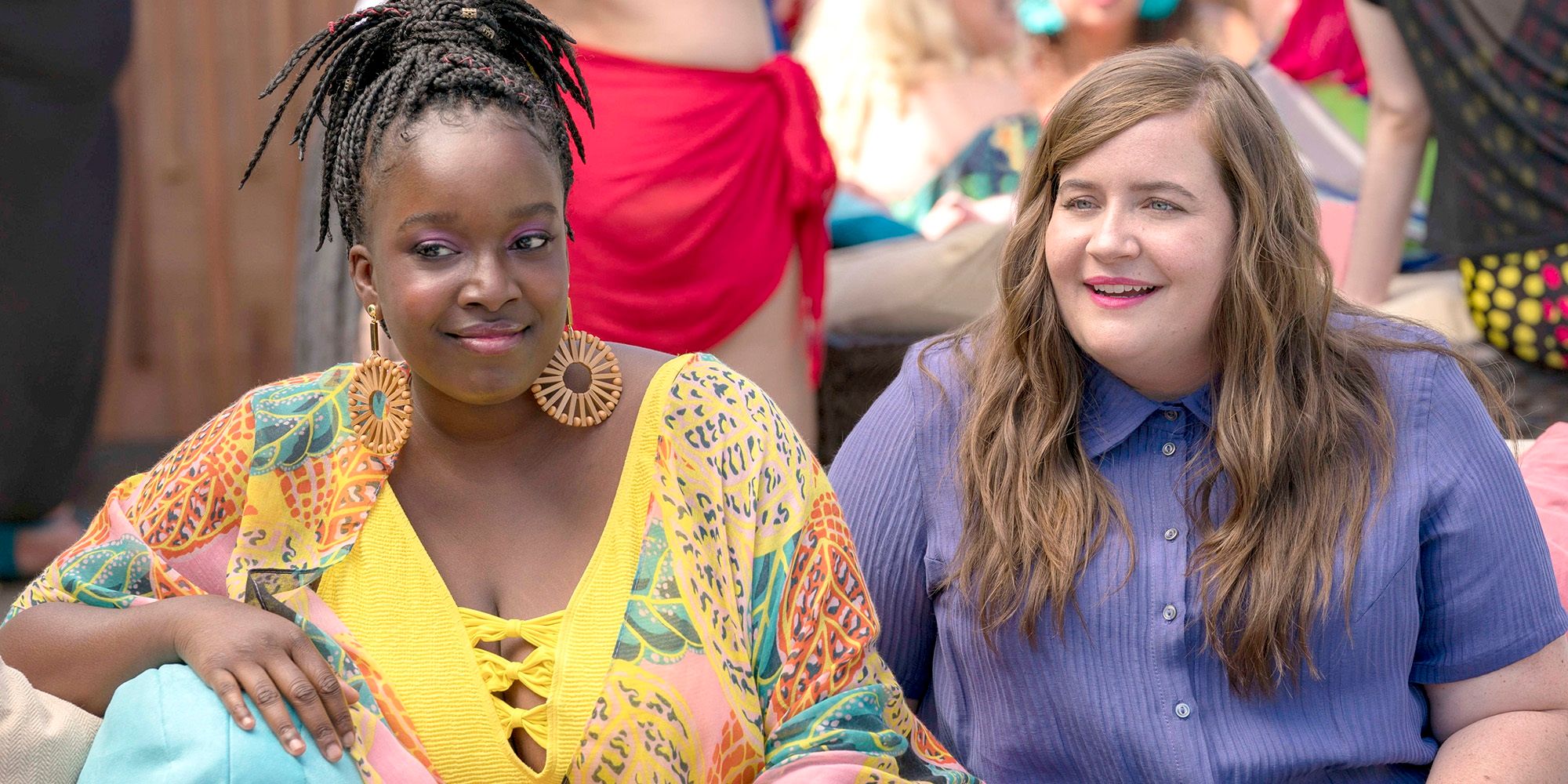 Fran (Lolly Adefope) and Annie Easton (Aidy Bryant) sitting together at a pool party in Shrill