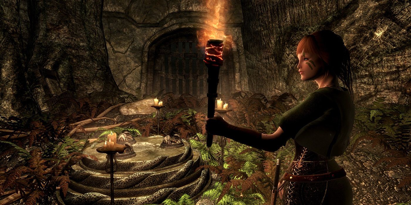 A shot of a character carrying a torch inside of Skyrim's ruins