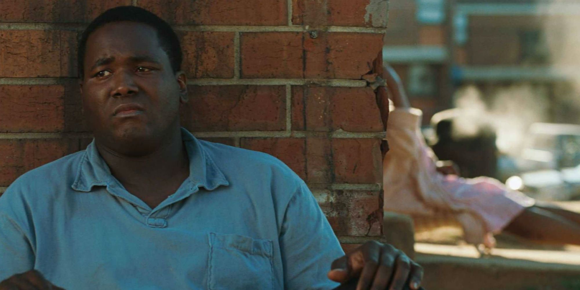 Michael Oher leans against a wall in The Blind Side