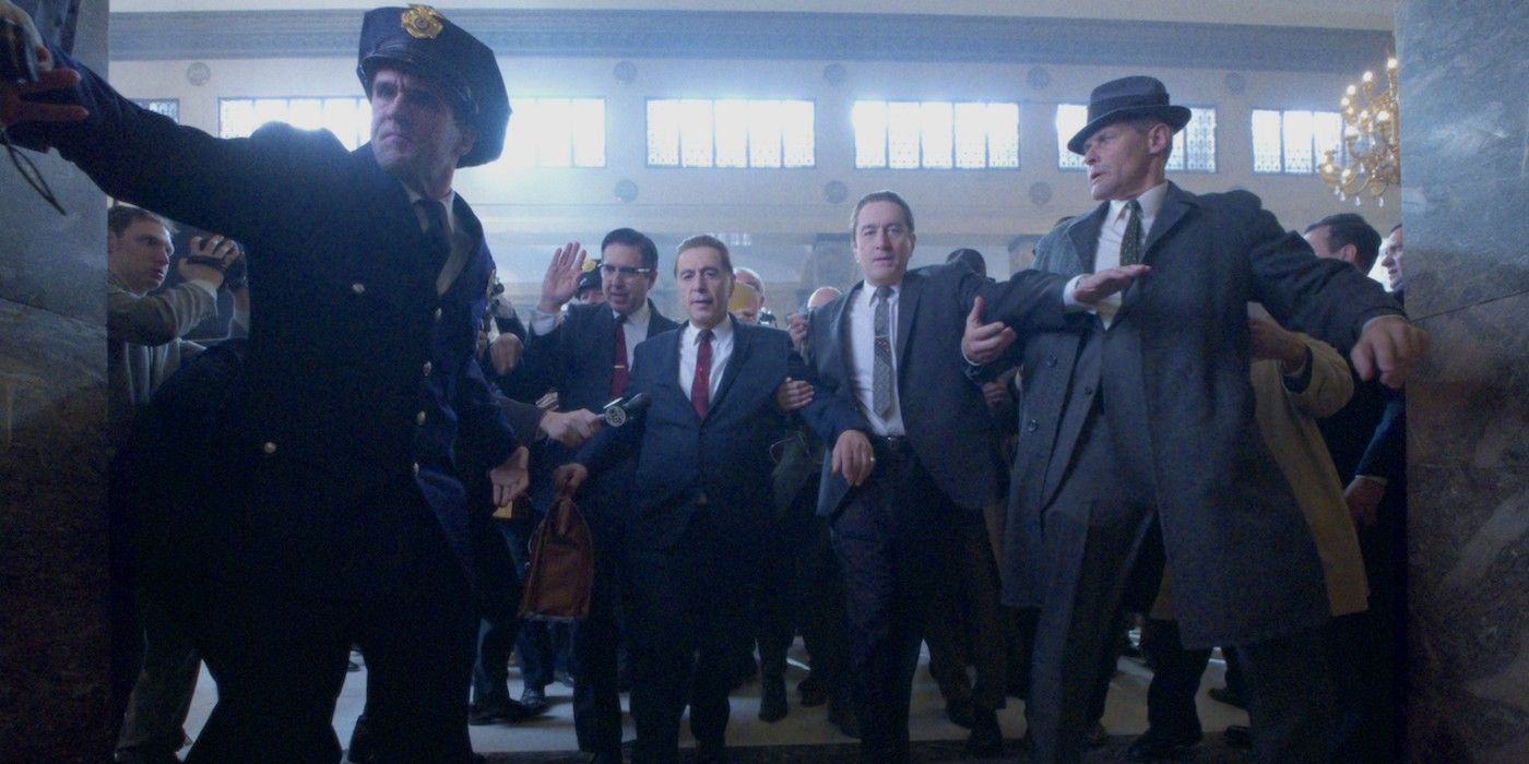 Police officers escort Jimmy Hoffa through a crowd in The Irishman