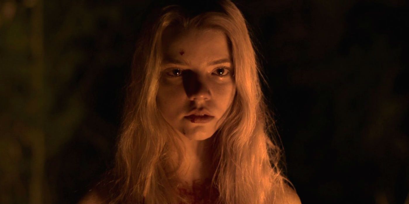 Anya Taylor Joy stands by a bonfire in The Witch 