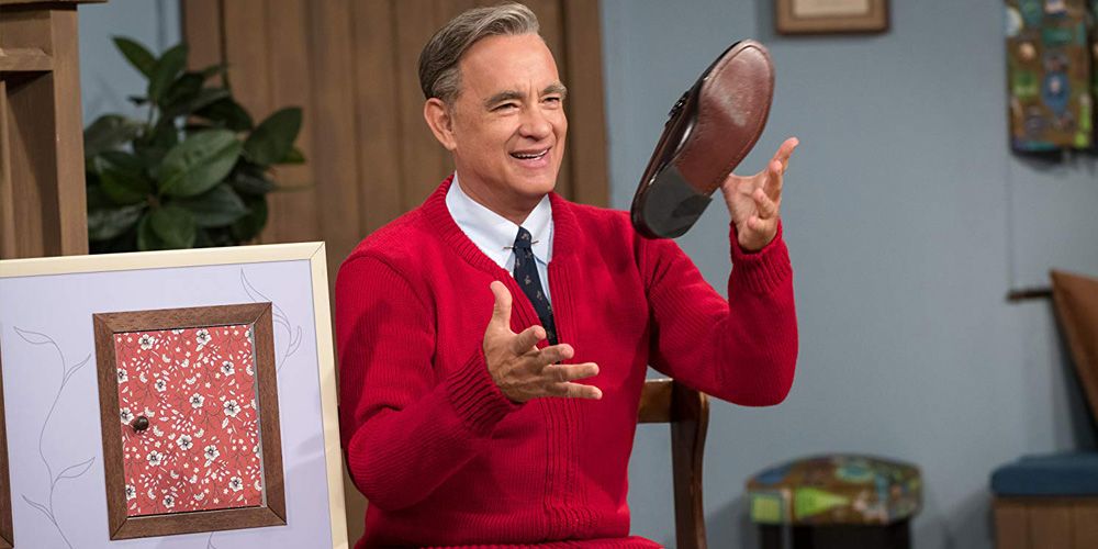 Tom Hanks, as Fred Rogers, tosses a shoe playfully in the air in A Beautiful Day in the Neighborhood