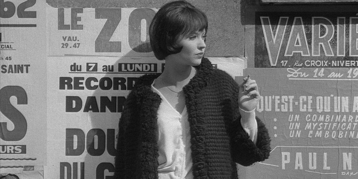 A woman holds a cigarette and leans on a wall in Vivre Sa Vie.