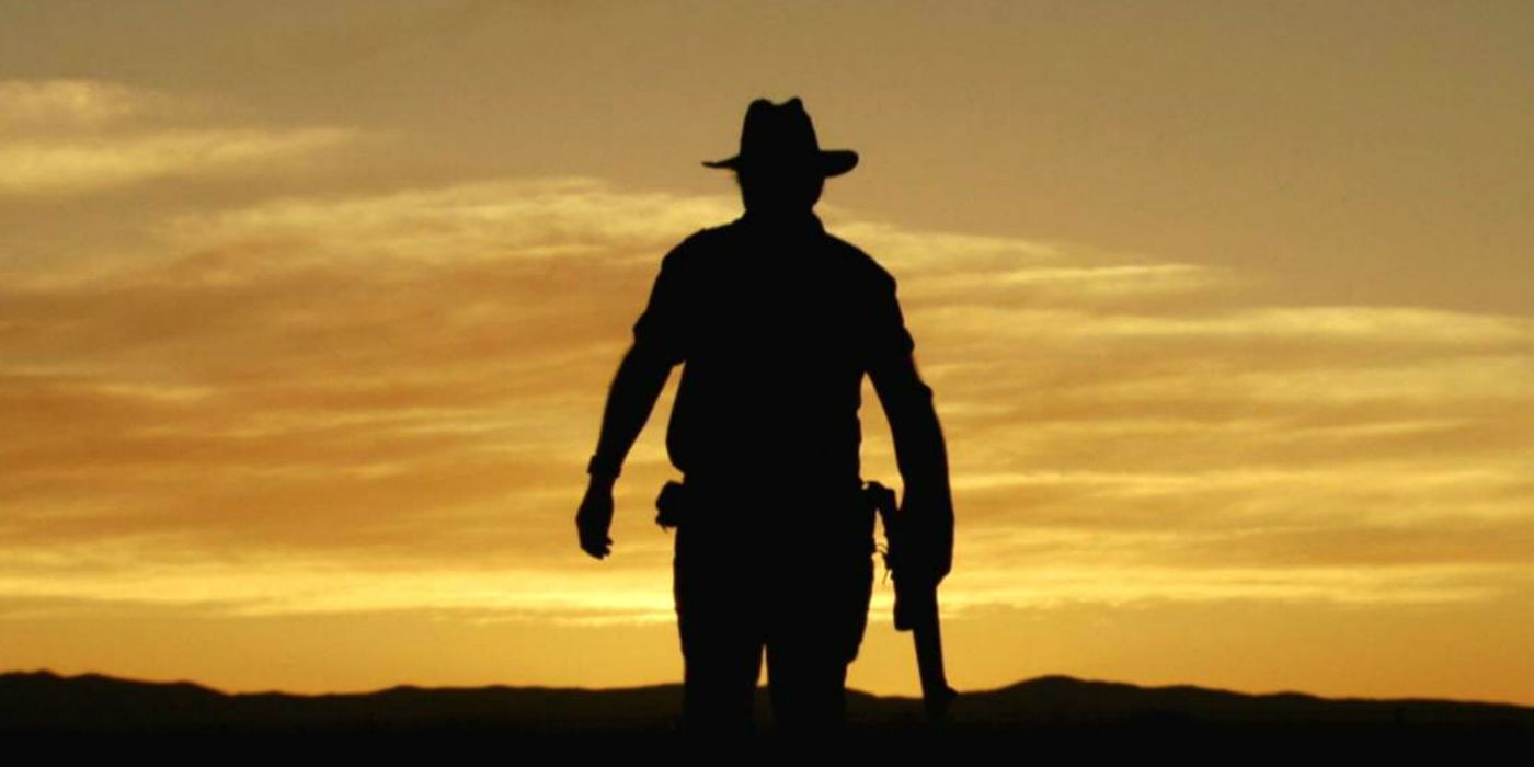 A shadow of John Jarratt as Mick Taylor holding his gun in Wolf Creek 2005 