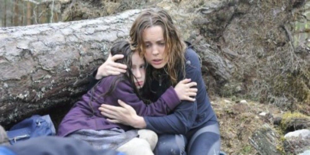 Alison abraçando Anna na frente de um tronco caído em A Lonely Place To Die