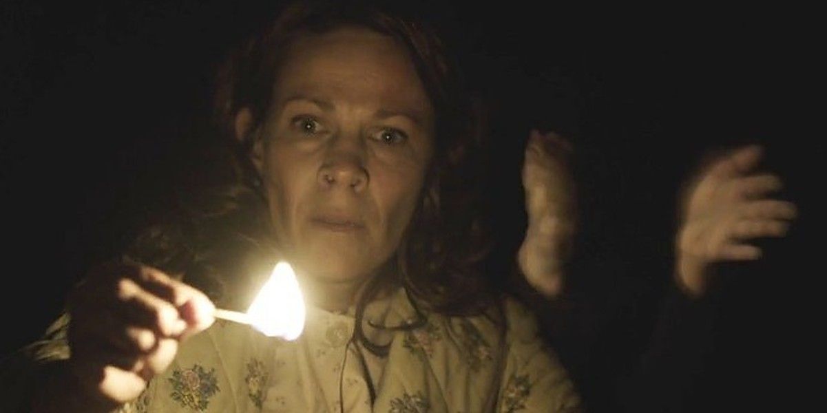 Woman holding a lit match in Conjuring.