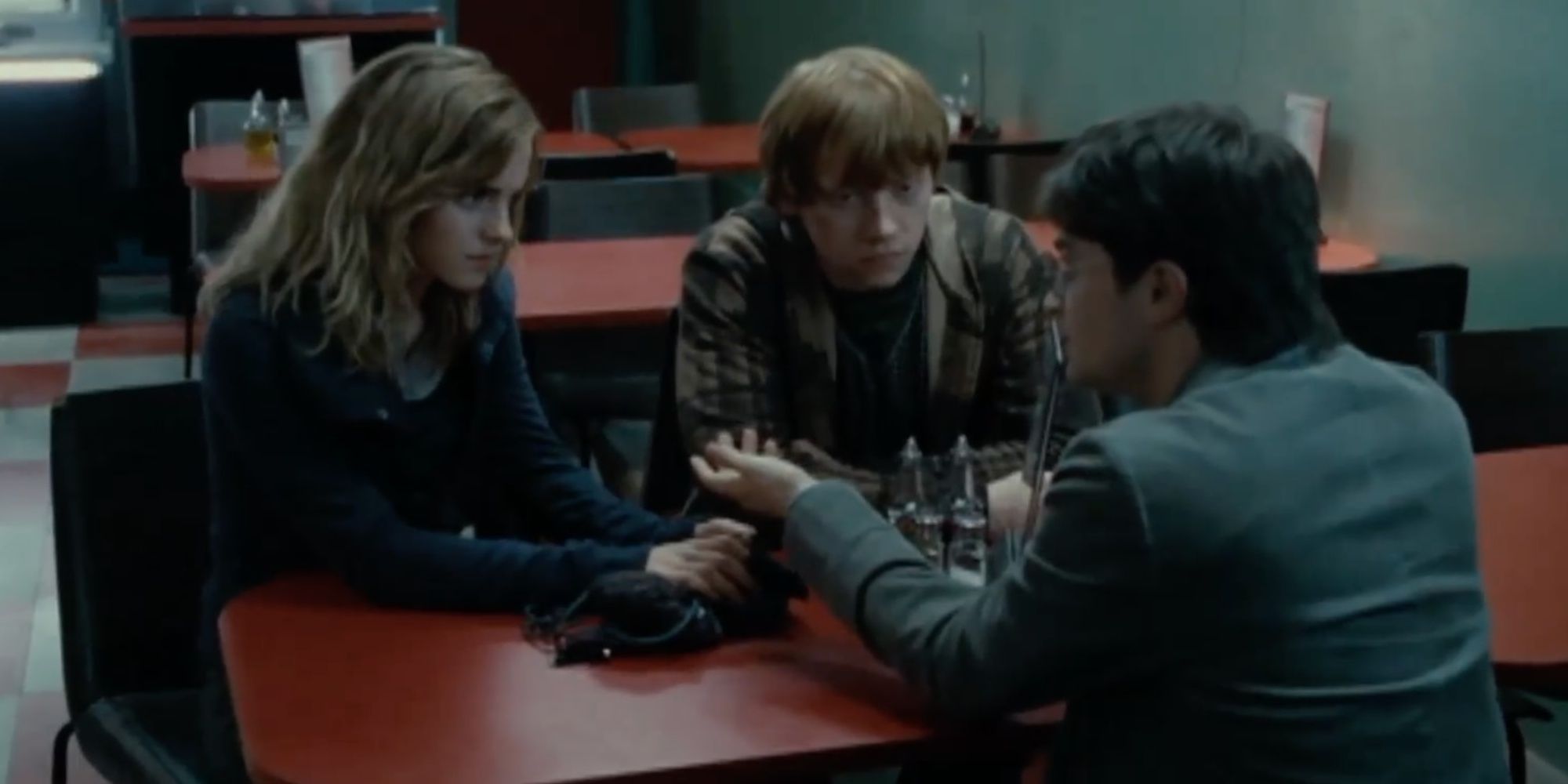 Ron sitting with Harry and Hermione in Deathly Hallows Part 1