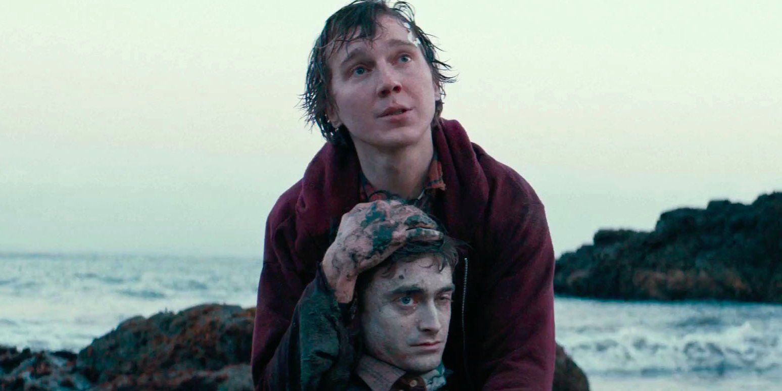 Hank holding Manny on a beach in Swiss Army Man