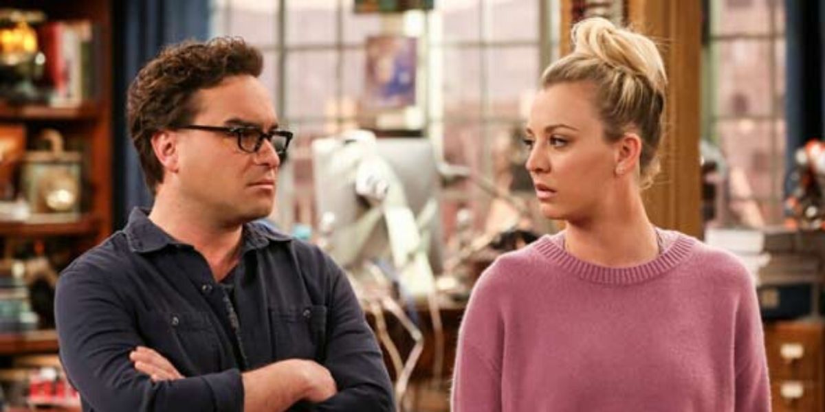 Leonard em uma camisa preta olhando para Penny que está ao lado dele em um suéter rosa em The Big Bang Theory