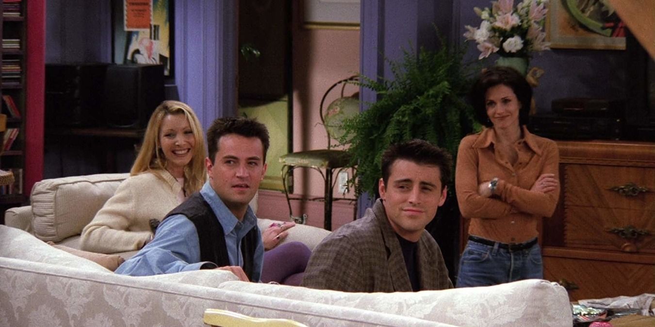 Chandler, Phoebe, Monica, and Joey sit on a sofa and smile in Friends