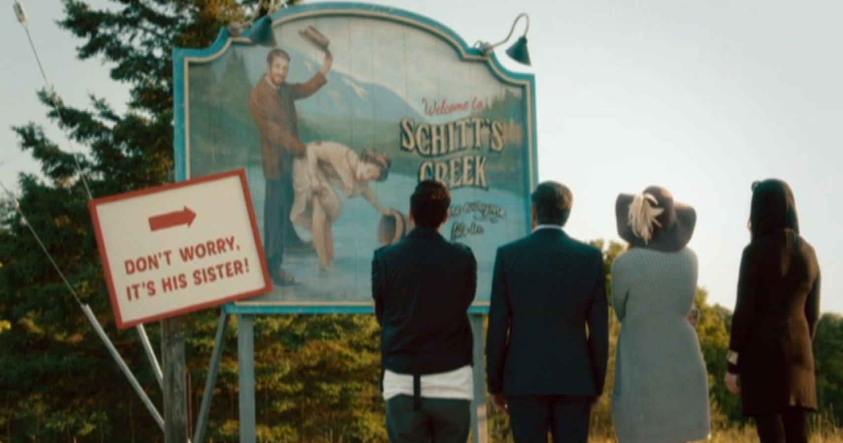 Schitt's Creek sign and Rose family looking at it