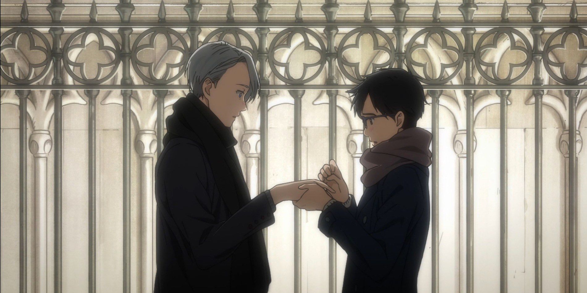 A screenshot from the Yuri!!! On Ice anime series of Yuri and Viktor standing in front of a gate holding hands.