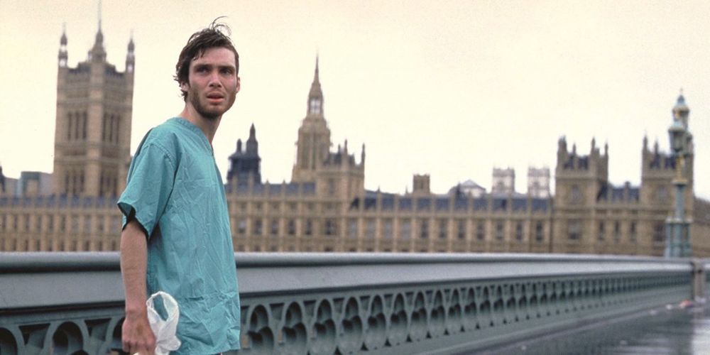 Cillian Murphy's character stands on a bridge in a nurse's outfit in 28 Days Later