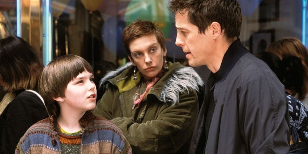 Hugh Grant and Nicolas Hoult talk while Toni Collette looks on in About a Boy