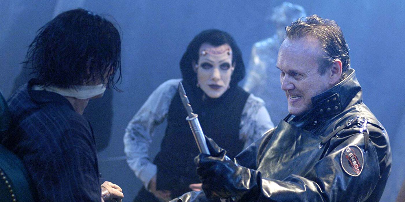 A man holds a large needle from Repo The Genetic Opera