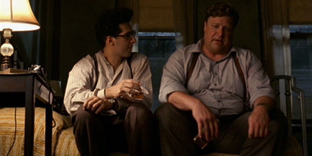 Dois homens sentados em uma cama e conversando em Barton Fink