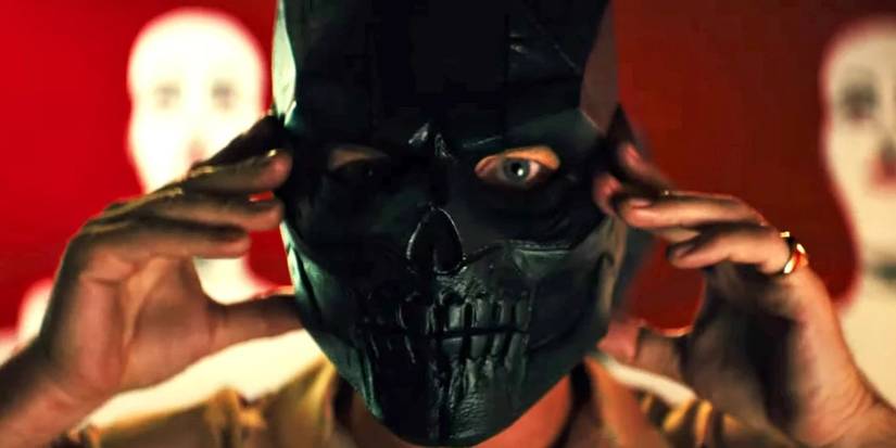 Roman Sionis holding up his black skull mask in Birds of Prey