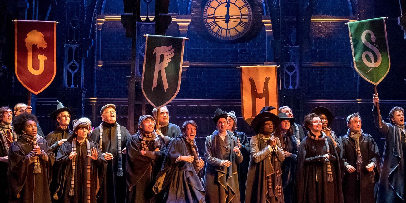 A group of Hogwarts students gather on stage with banners in Harry Potter &amp; The Cursed Child.