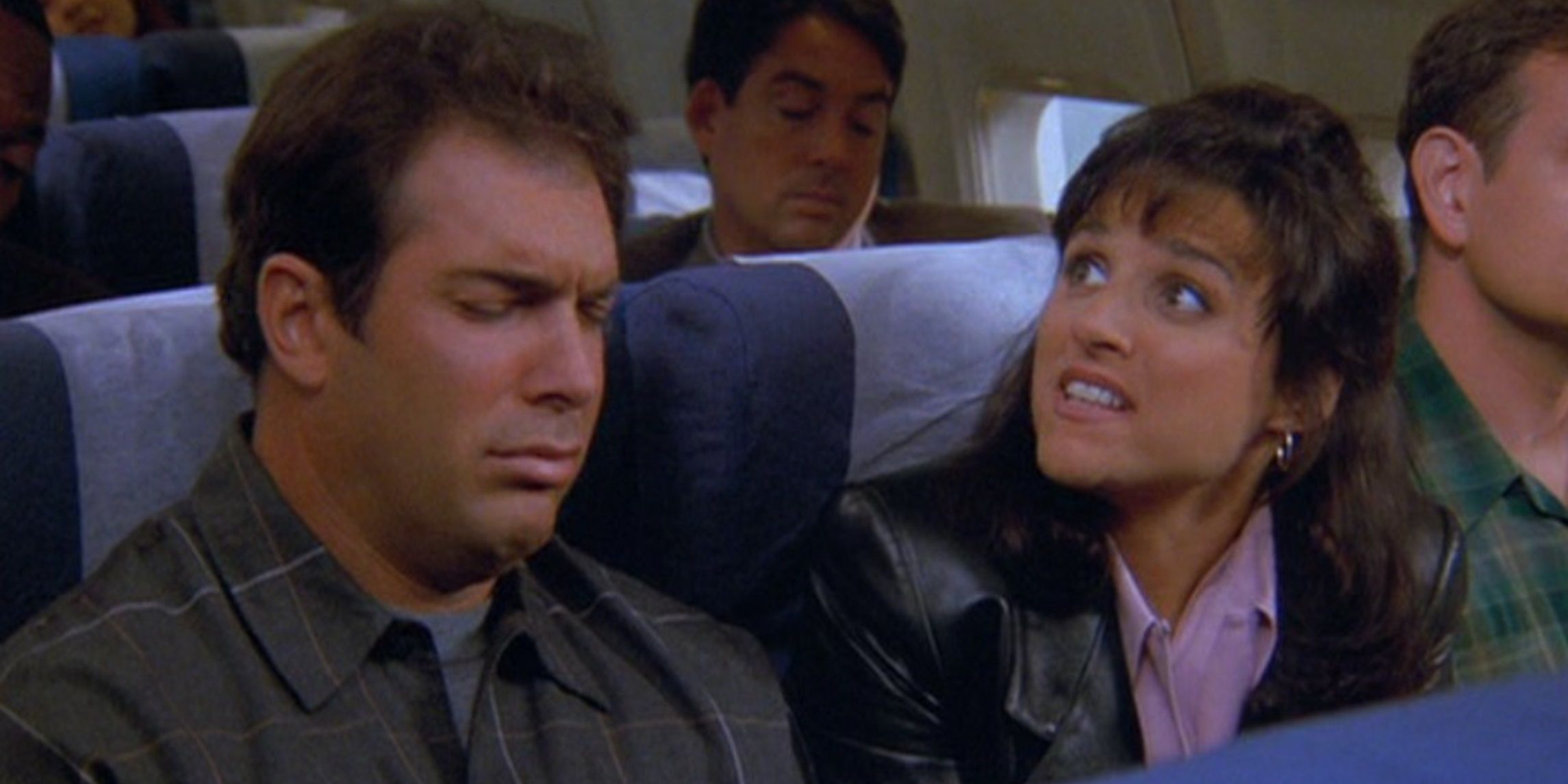Puddy and Elaine sitting in an airplane