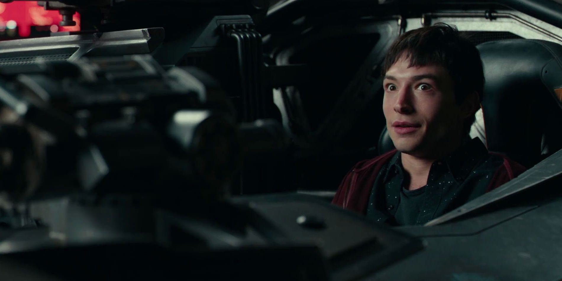 Barry Allen smiling while sitting in Batmobile