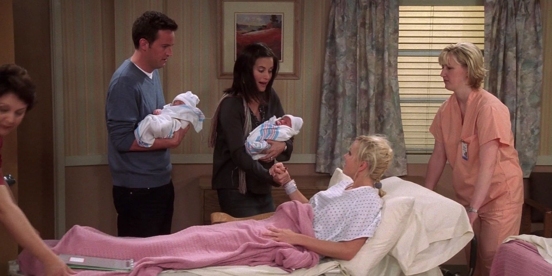 Monica and Chandler holding the newborn twins over Erica in a hospital bed in Friends