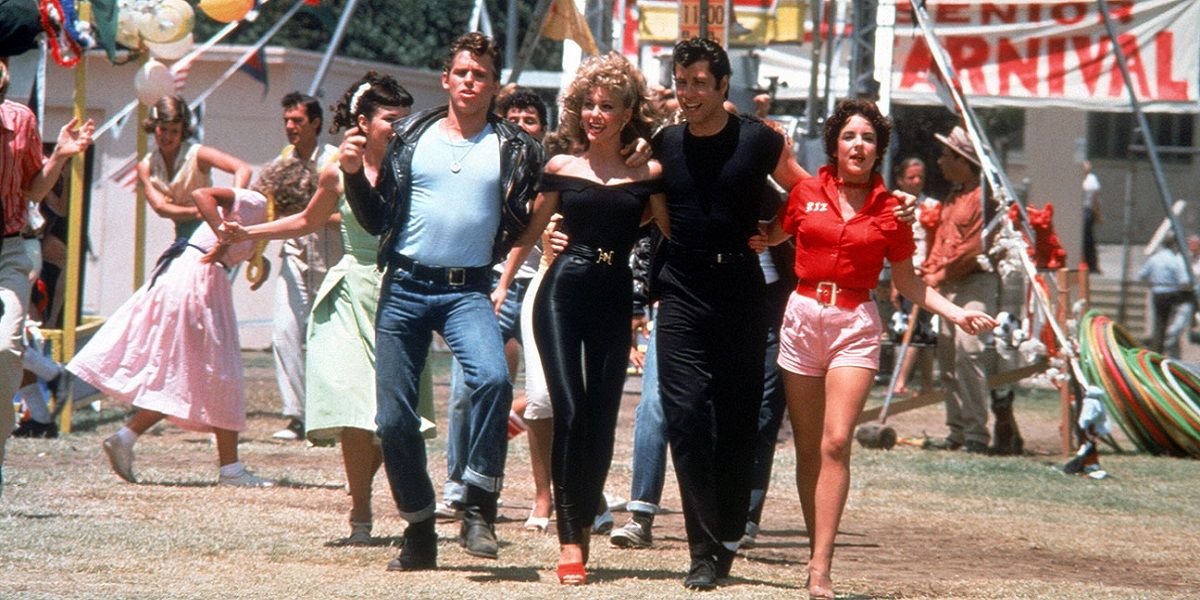 The leading cast of Grease walking through the carnival