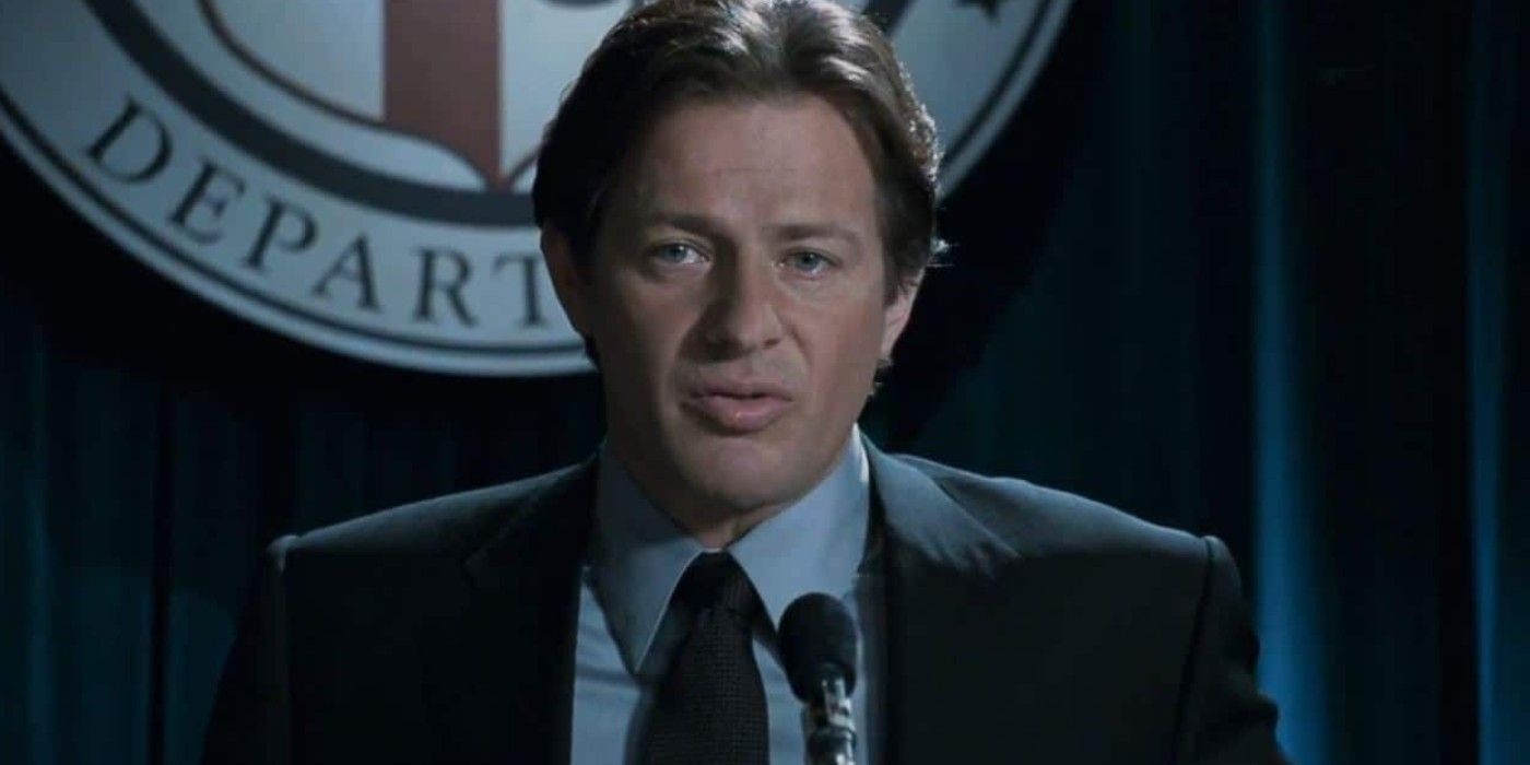 Hoffman stands in front of a microphone in Saw V