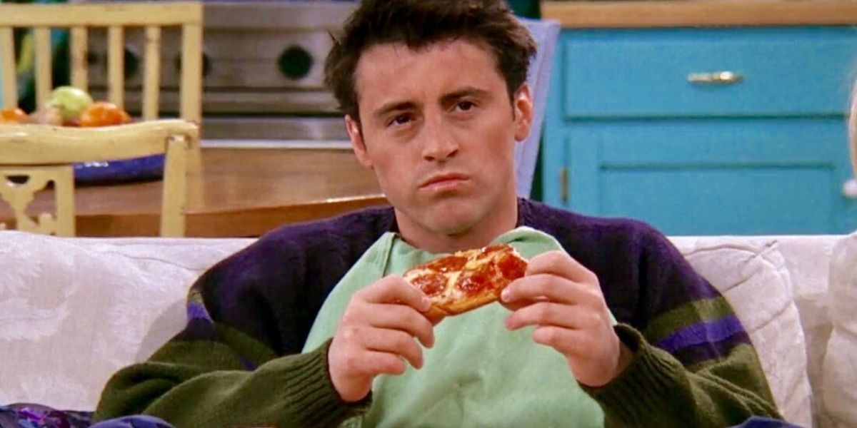 Joey eating pizza on the sofa in Friends
