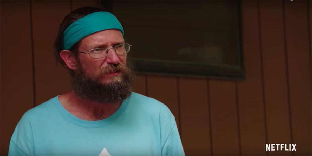 Joey Greene Queer Eye in headband and green t-shirt serious look on face