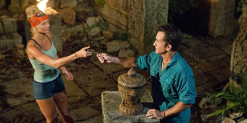 Kelley Wentworth handing an immunity idol to Jeff Probst in Survivor: Cambodia