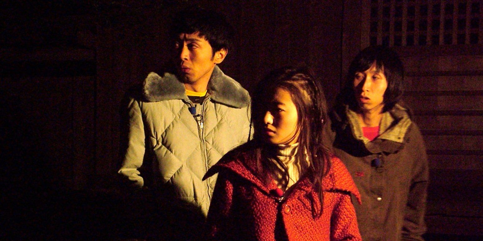 Three teenagers wear jackets and look at something offscreen in Noroi: The Curse.