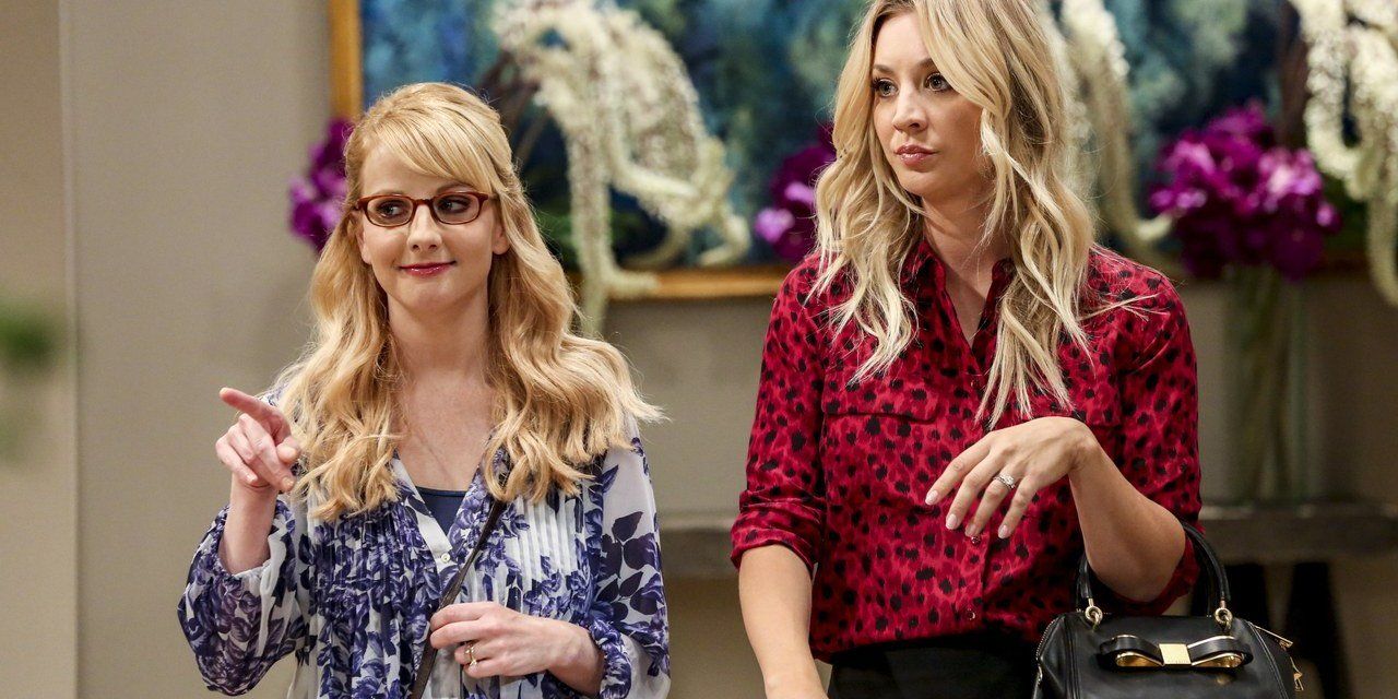 Bernadette em um top azul e branco ao lado de Penny em um top vermelho em The Big Bang Theory