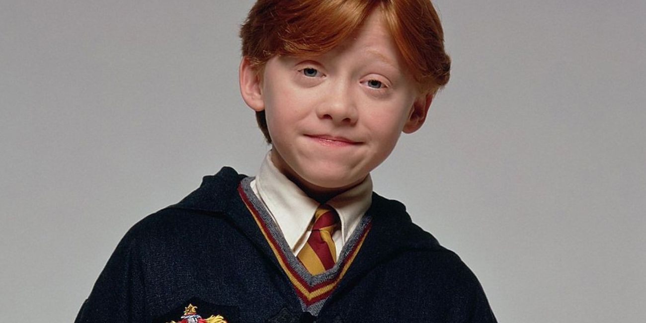 Rupert Grint as young Ron Weasley smiling and wearing his Gryffindor uniform