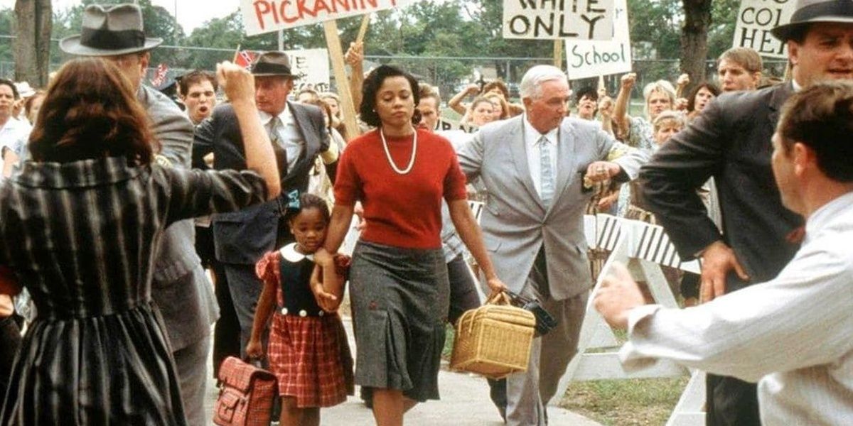 A Black woman walks through a protest in Ruby Bridges