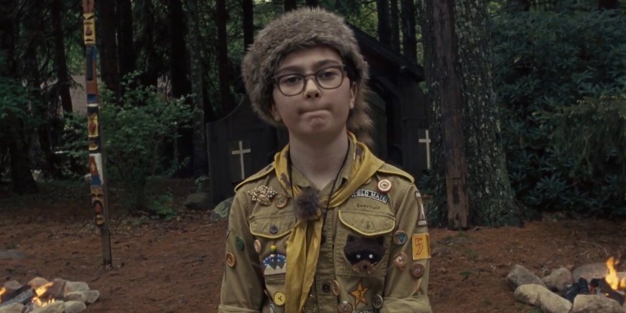 Sam by a fire in the woods in Moonrise Kingdom.