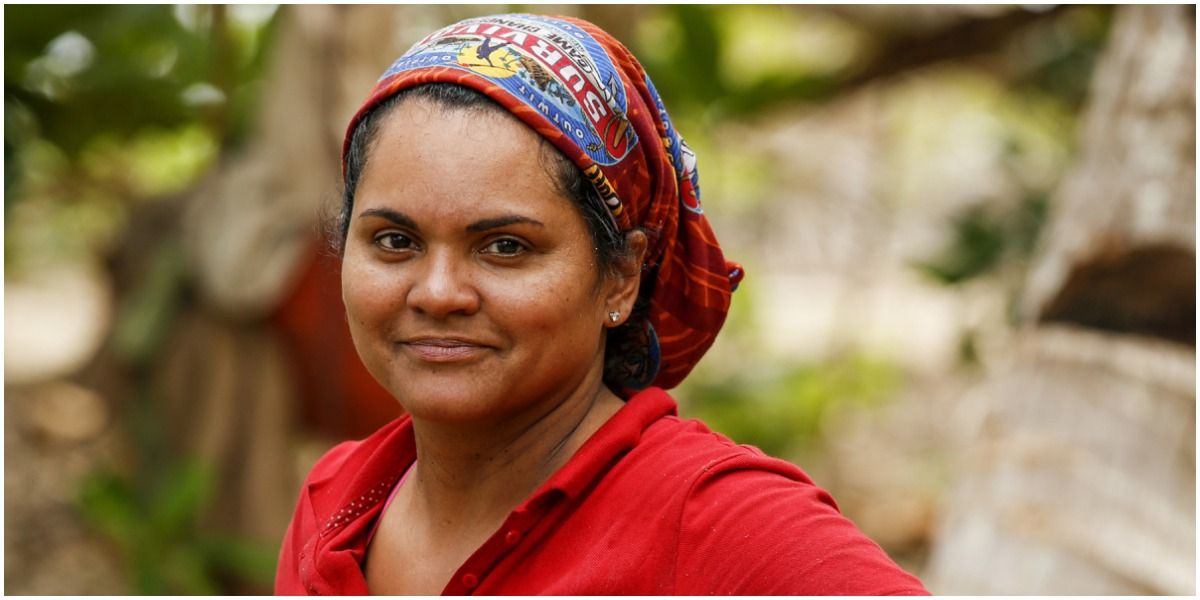 Sandra Diaz-Twine from Survivor wearing red and smiling with her buff on her head.
