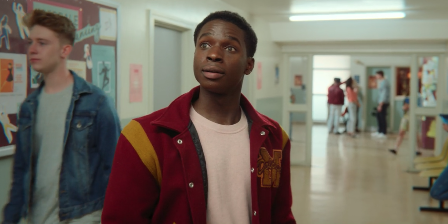 Jackson wears his varsity jacket and standing in the hall at school