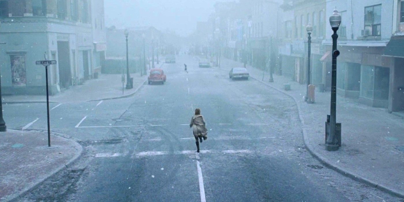 A woman runs down an empty street in Silent Hill