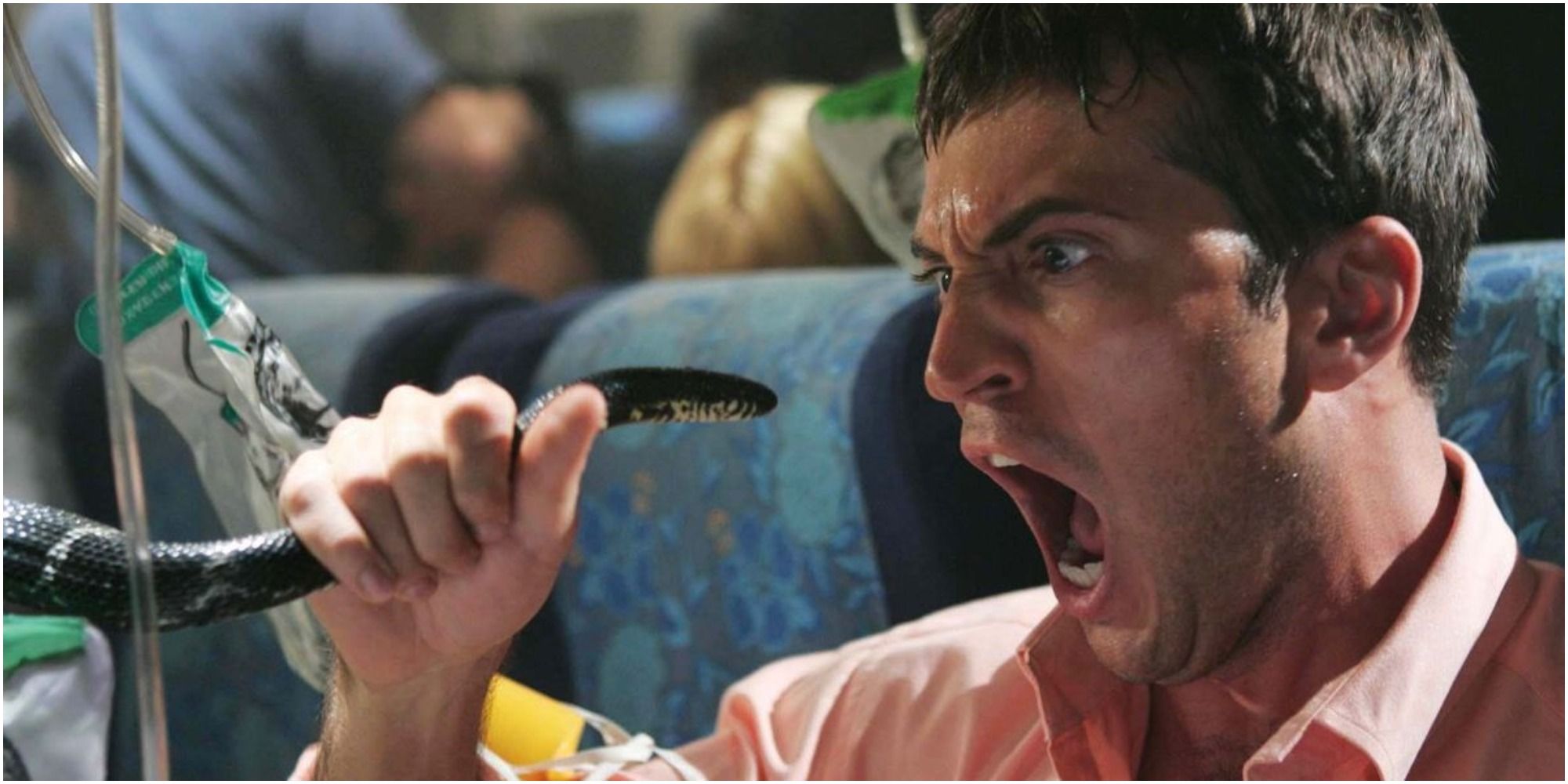 A man holding a snake and screaming