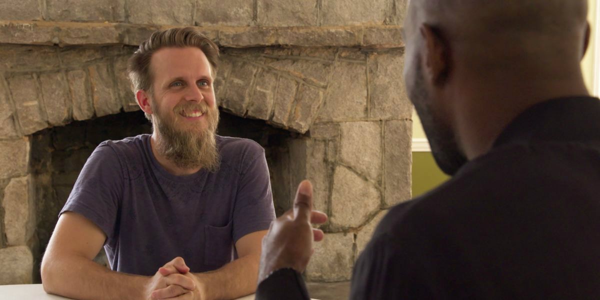 Ted Queer Eye smilng near fireplace