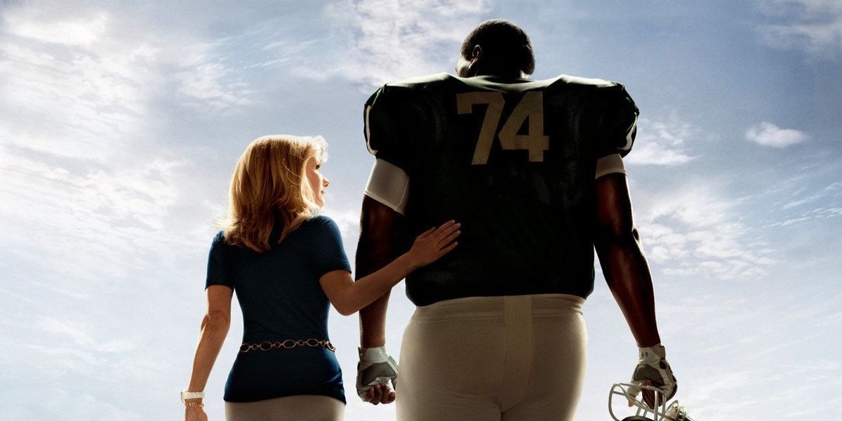 Uma mulher branca andando com um jogador de futebol negro em The Blind Side